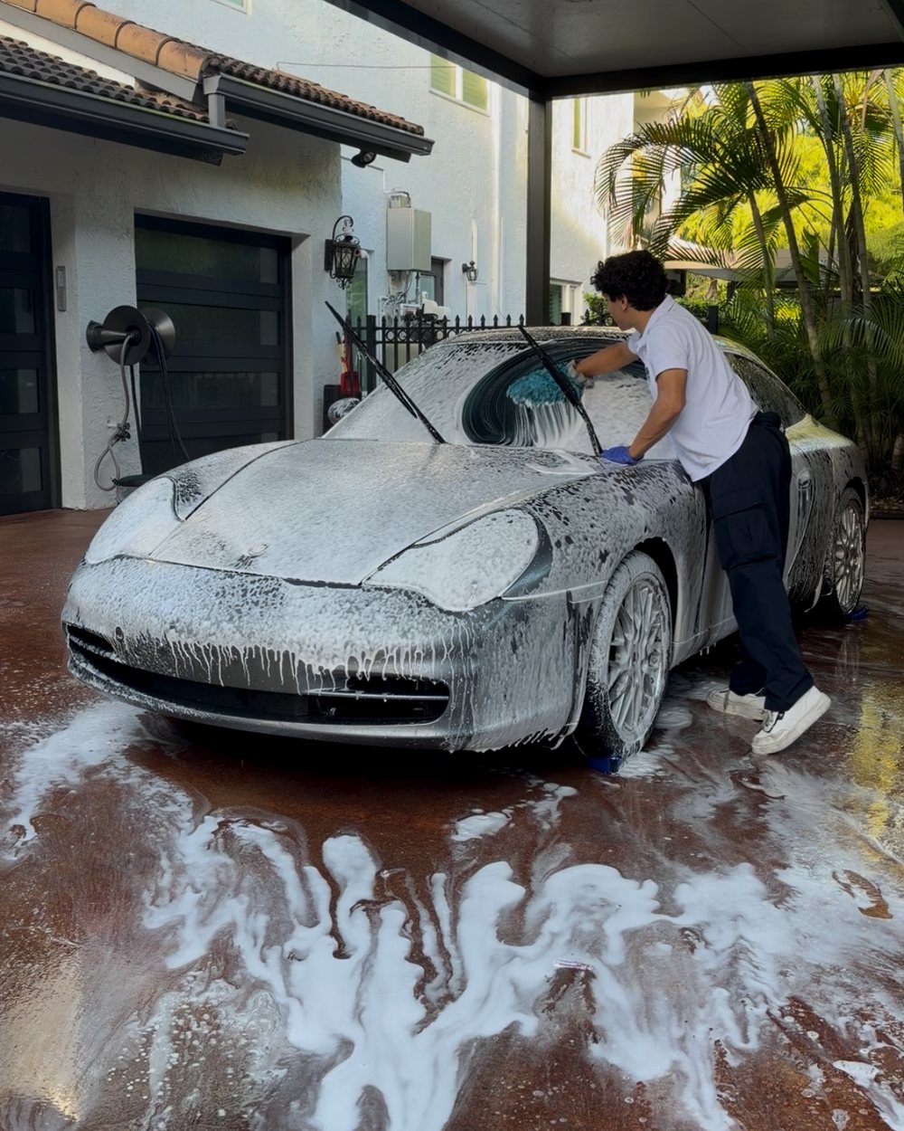 Andres foam-washing a silver Porsche 911 in a Pembroke Pines driveway